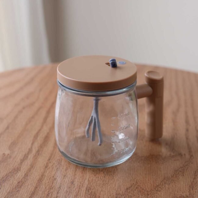 Automatic blender cup with dark beige plastic lid and grey inlet