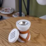 مبخرة سيراميك بيضاء بملمس مميز ملفوفة بحزام جلدي بني.