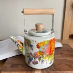 ابريق شاي مطلية بالمينا  بنقشة زهور مع مقبض خشبي