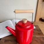 ابريق شاي مطلية بالمينا مع مقبض خشبي